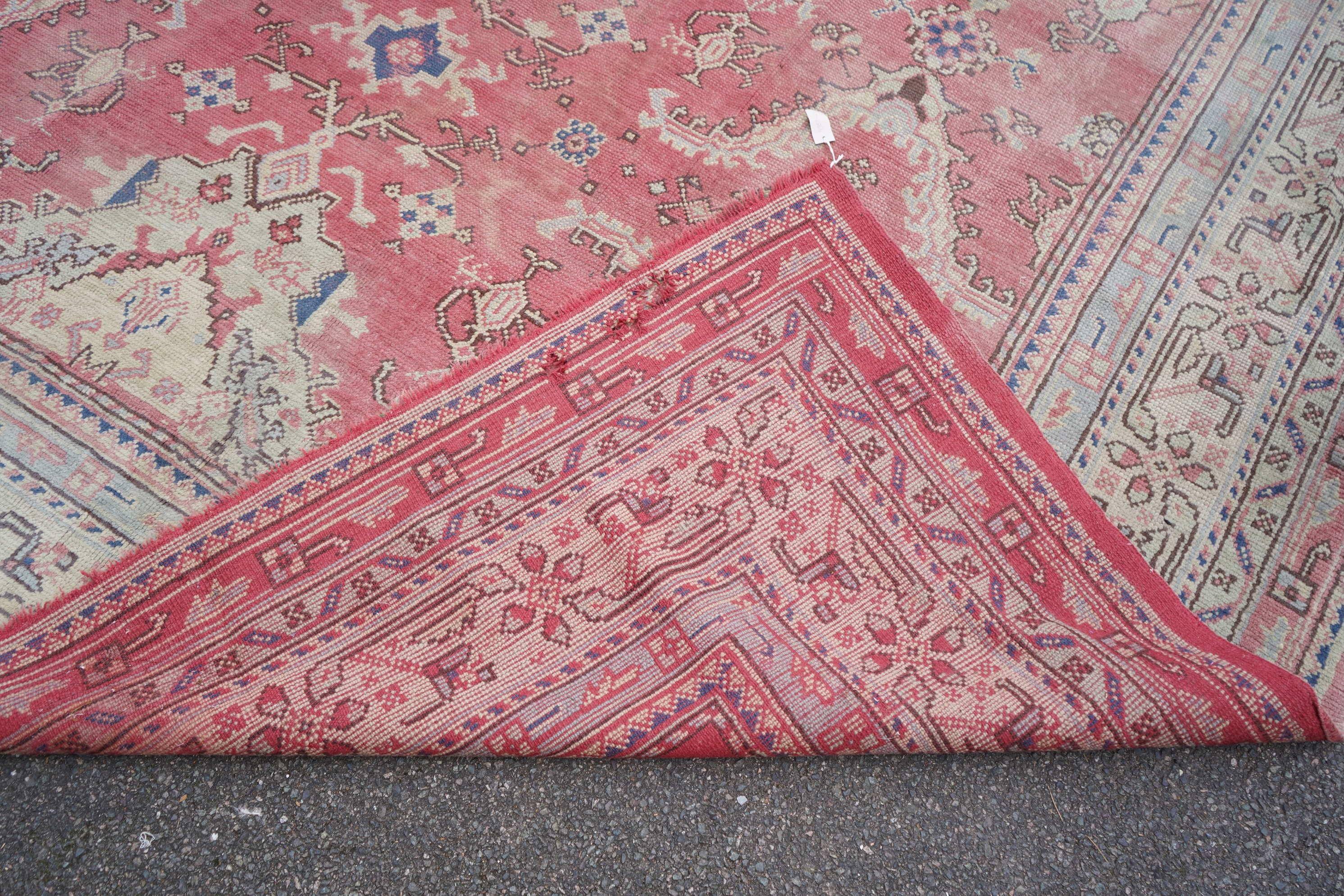 A large Turkish faded red ground carpet